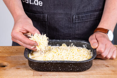 Kartoffelgratin mit Käse bestreuen