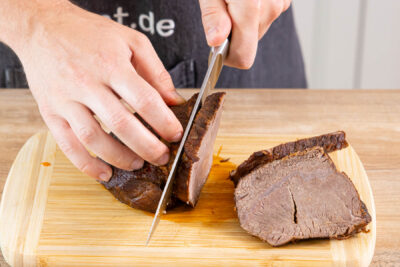 Klassischen Rinderschmorbraten gegen die Faser aufschneiden