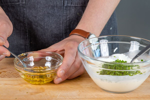Knoblauch und Schnittlauch in Knoblauch-Dip mit Schmand geben