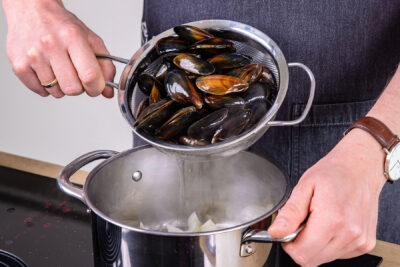 Miesmuscheln in den Topf geben