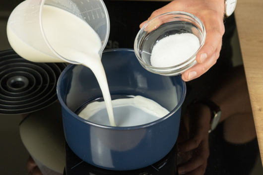 Milch und Zucker in einen Topf geben
