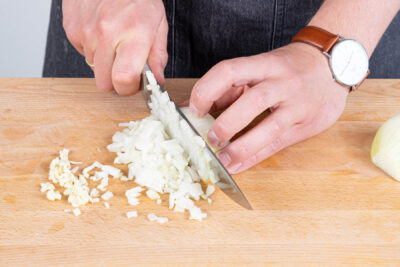 Zwiebeln und Knoblauch schälen und fein würfeln