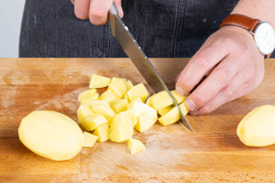 Kartoffeln in Stücke schneiden