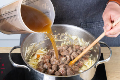Fleisch und Brühe in den Topf geben