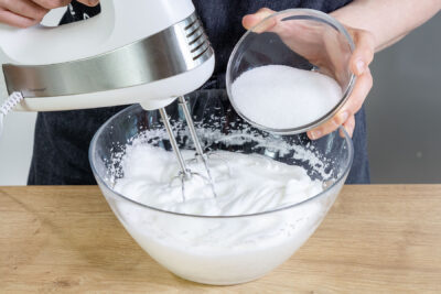 Zucker zum Eiweiß geben