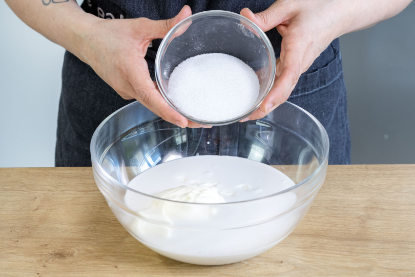 Zucker zur Buttermilch und zum Joghurt geben