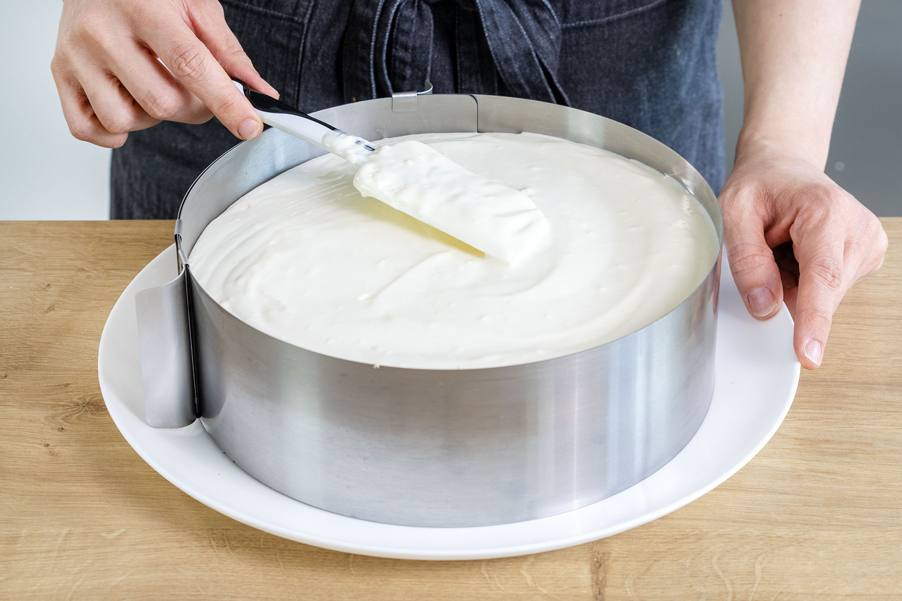 Kokoscreme der fruchtigen Piña-Colada-Torte verstreichen