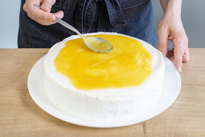 Fruchtspiegel auf der Piña-Colada-Torte verteilen
