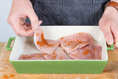 Schnitzelfeisch halbieren, würzen und in die Auflaufform geben