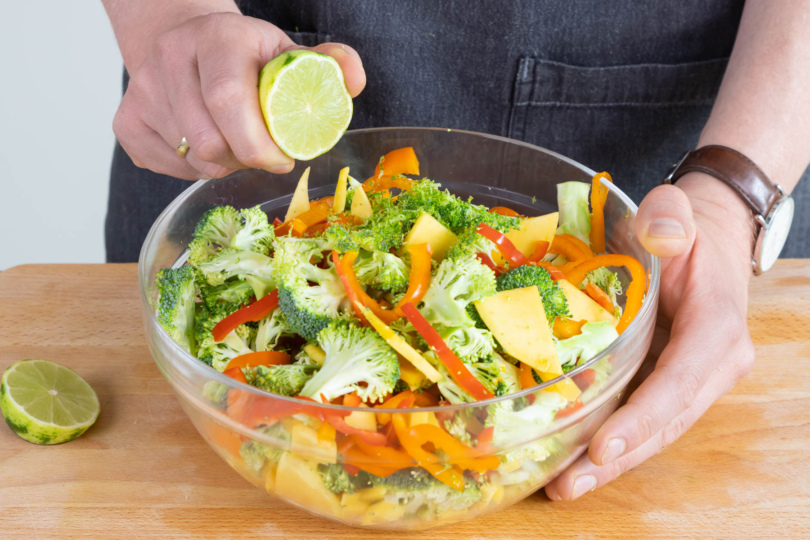 Abrieb und Saft der Limette zum rohen Brokkoli-Salat geben