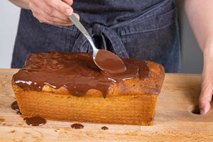 Glasur über Bananenkuchen geben