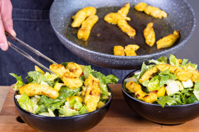 Salat mit Putenstreifen anrichten