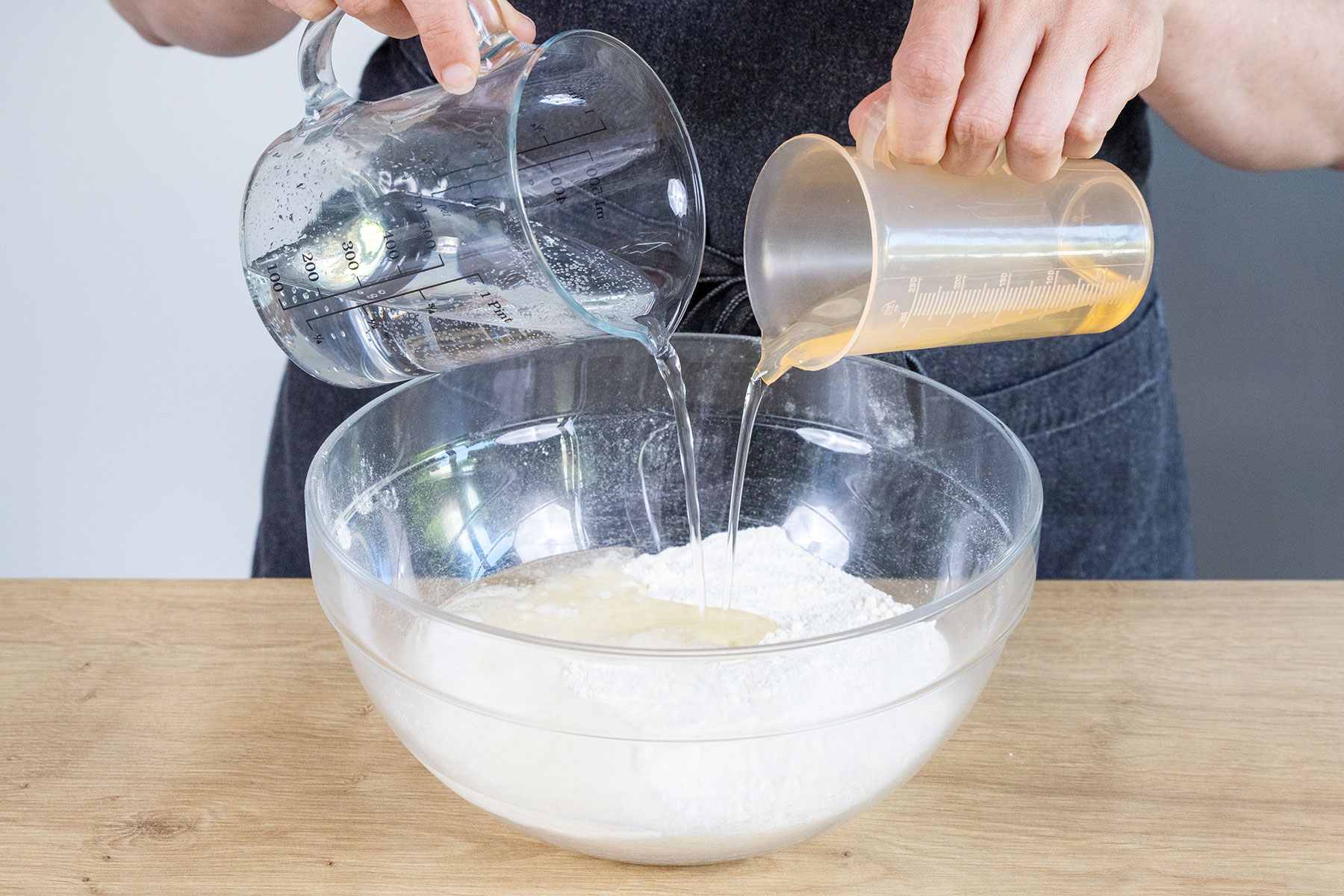 Mineralwasser und Öl zum Mehl und Zucker geben