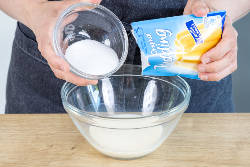 Puddingpulver und Zucker zur Hafermilch geben
