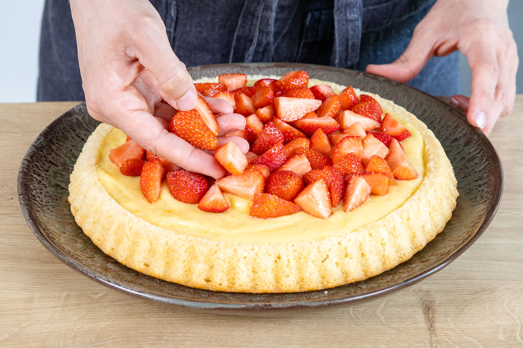 Erdbeeren auf dem Kuchen verteilen