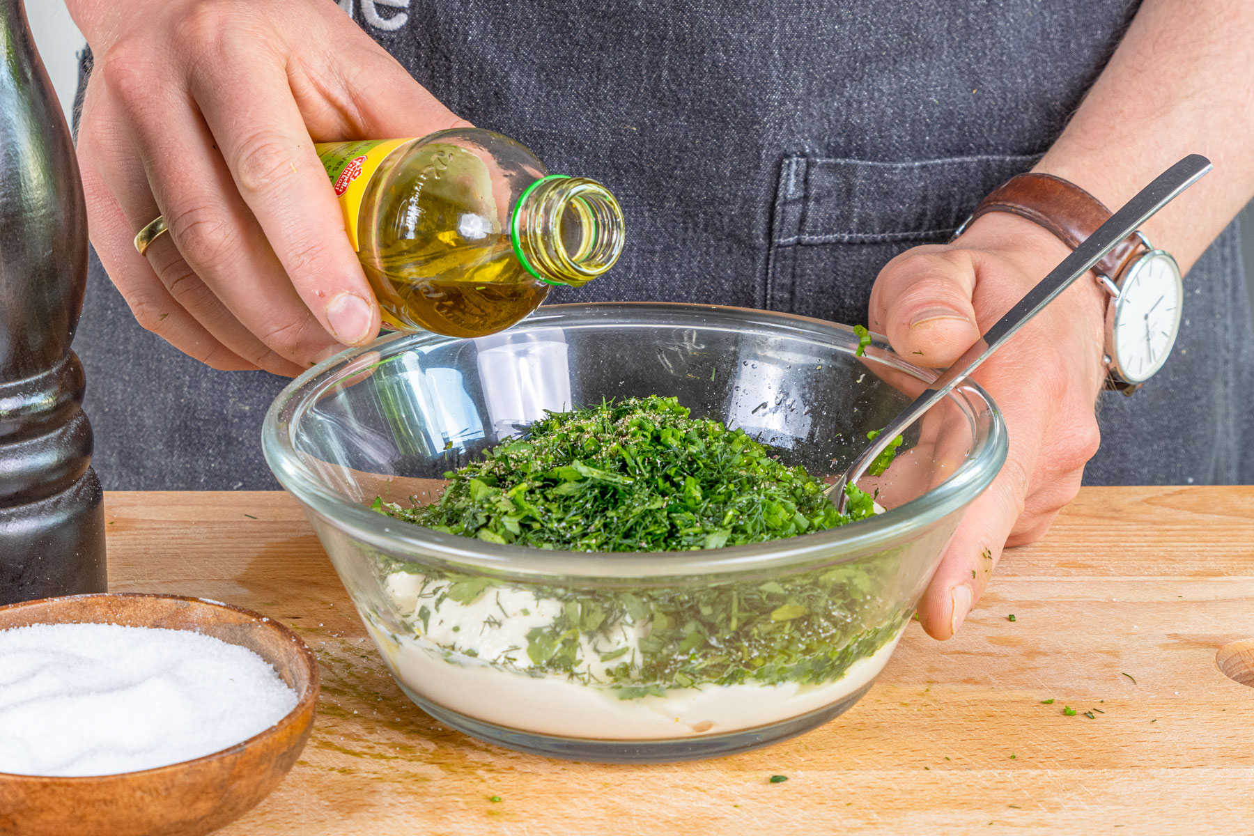 Olivenöl zum veganer Kräuterquark gießen