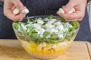 Mozzarella auf den Schichtsalat geben