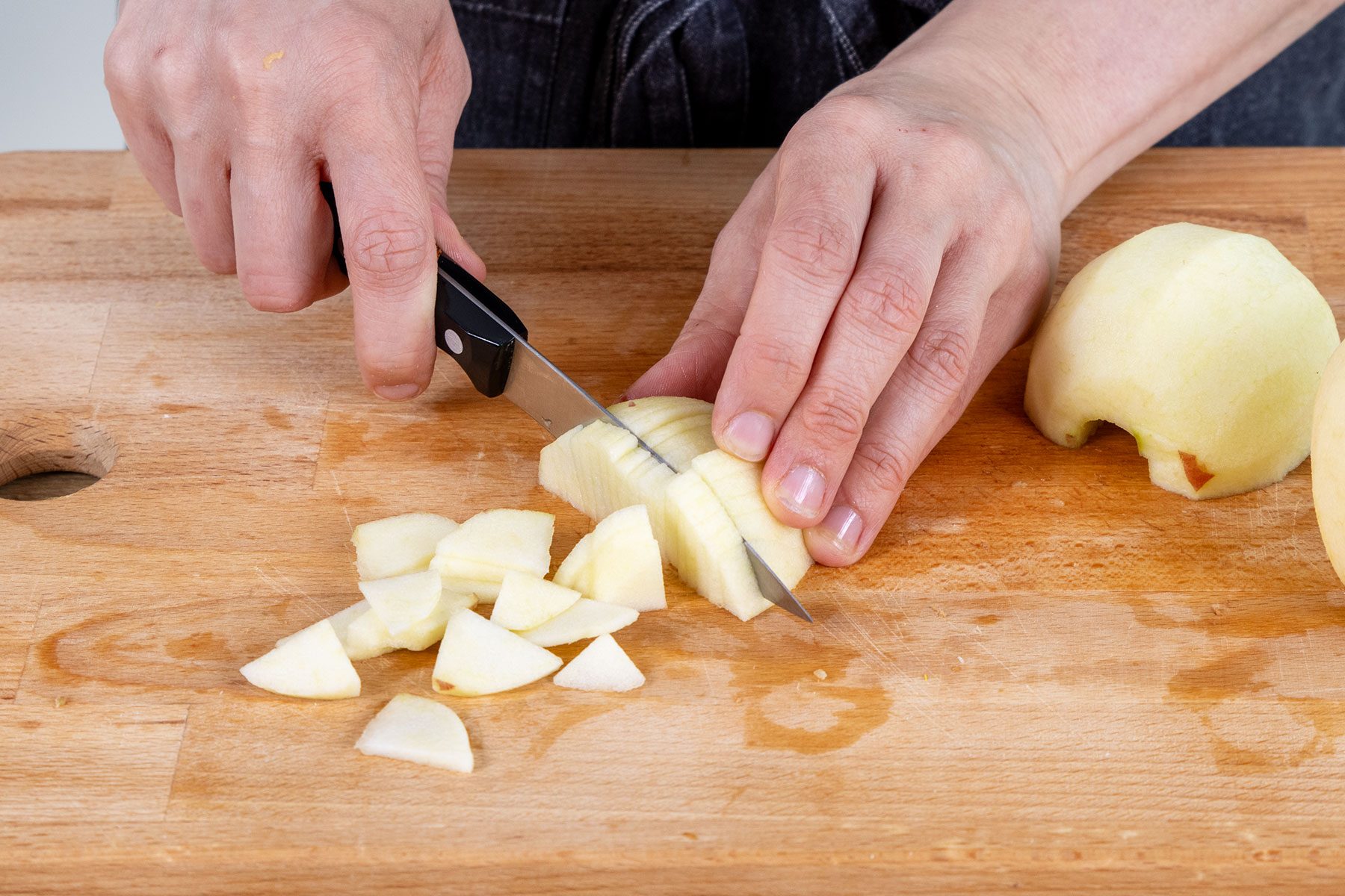 Äpfel für die Apfel-Sahne-Torte in kleine Stücke schneiden