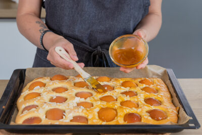 Aprikosenkuchen mit Marmelade bestreichen
