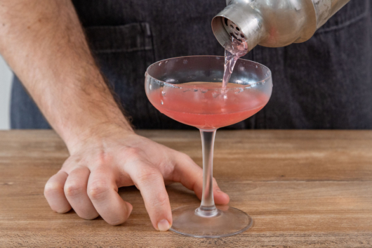 Cosmopolitan Cocktail in Martiniglas gießen