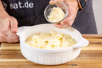 Einfaches Kartoffelgratin mit Parmesan bestreuen