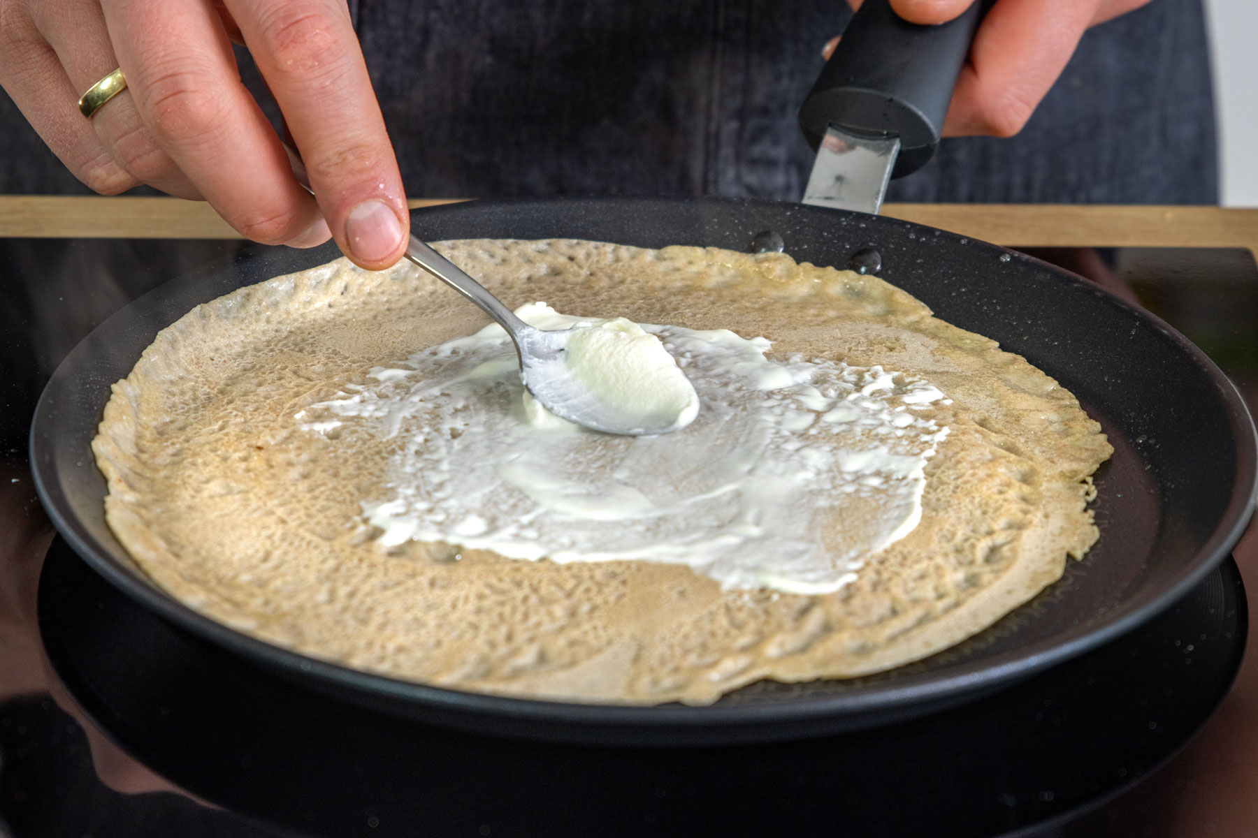 Buchweizenpfannkuchen mit Crème fraîche bestreichen