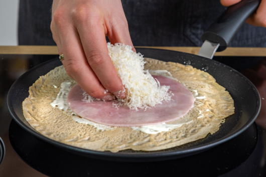 Käse auf den Schinken geben