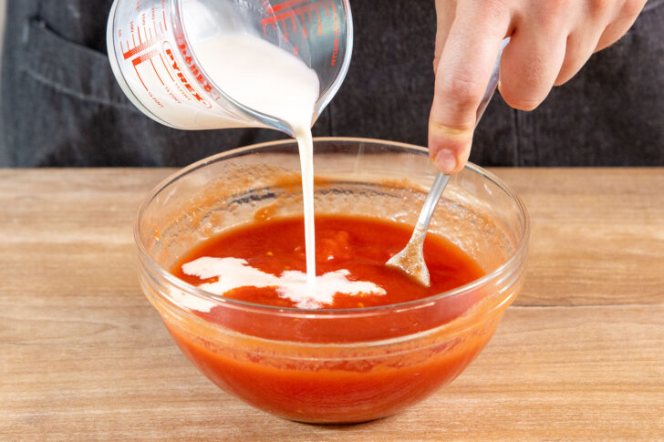 Sahne zu den Tomaten gießen