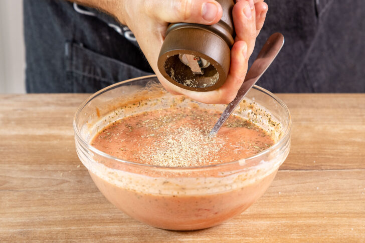 Tomatensoße mit Pfeffer würzen