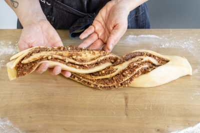 Stränge des saftigen Hefe-Nusszopfs nach Omas Rezept verdrehen