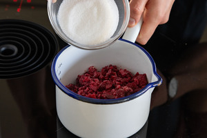 Himbeeren und Zucker in den Topf geben