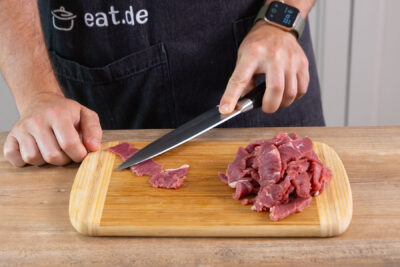 Fleisch mit dem Messerrücken in feine Streifen drücken.