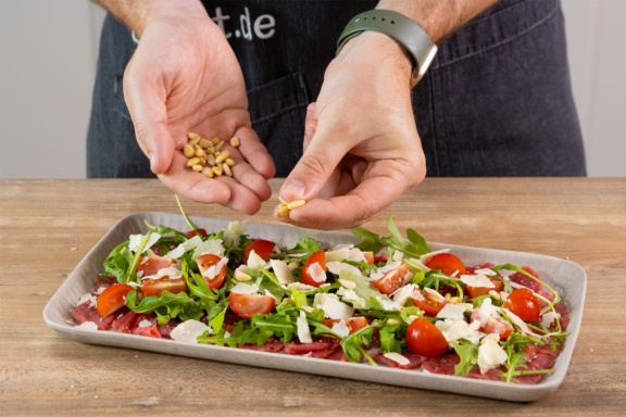 Parmesan über das Rindercarpaccio geben.