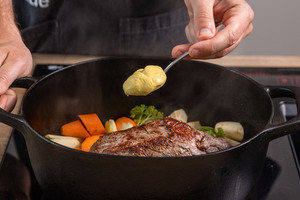 Senf zum Fleisch in den Bräter geben