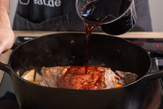 den Rinderschmorbraten mit Rotwein ablöschen