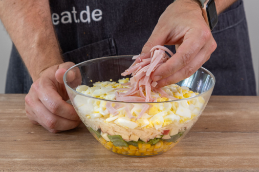 Schinken im Schichtsalat verteilen