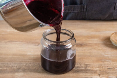 schwarze Johannisbeermarmelade ohne Kerne in ein steriles Glas füllen