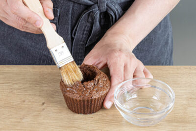 Schwarzwälder-Kirsch-Muffin mit Kirschwasser bestreichen