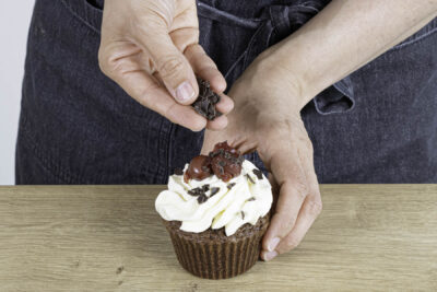Schwarzwälder-Kirsch-Muffins mit Sahne und Schokostreusel dekorieren