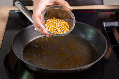 Popcorn-Mais in die Pfanne geben