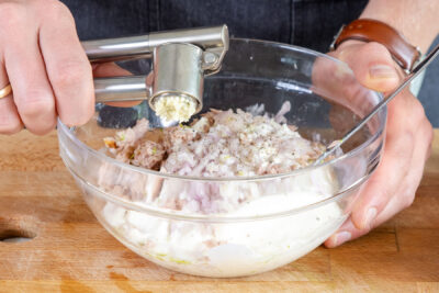Knoblauch zum Thunfisch-Dip pressen