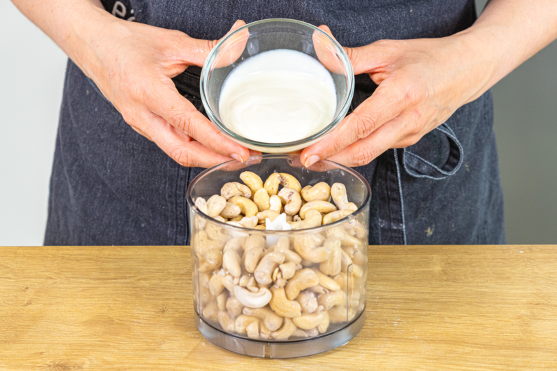 Sojajoghurt zu den Cashewkernen in den Mixer geben
