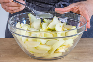 Zitronensaft zu den Apfelspalten geben