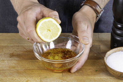 Zitronenschale und -Saft zum Dressing geben