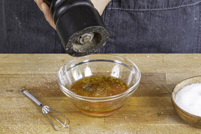 Dressing mit Salz und Pfeffer abschmecken