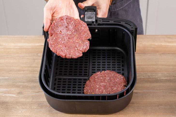 Burgerpatties in die Heißluftfritteuse geben