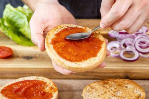 Burger-Brötchen mit Ketchup bestreichen