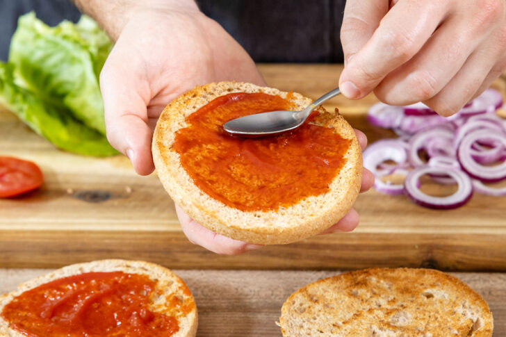 Burger-Brötchen mit Ketchup bestreichen