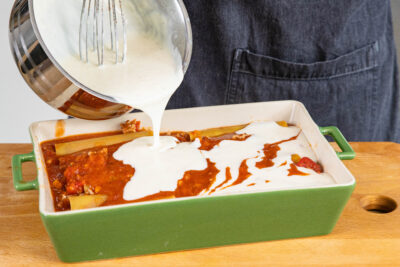 Cannelloni mit Béchamelsauce bedecken