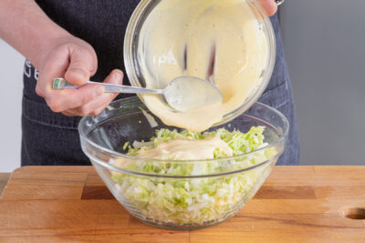 Dressing und Chinakohlsalat vermengen